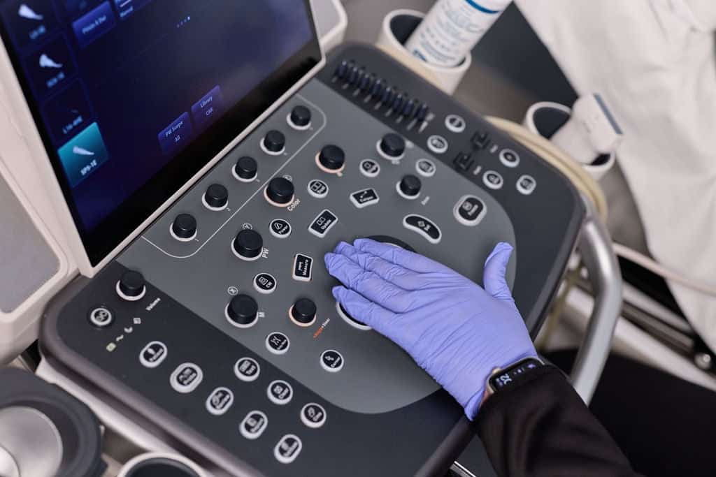 Ultrasound technologist operating the trackball and control panel of a diagnostic ultrasound system for Cardiac Testing
