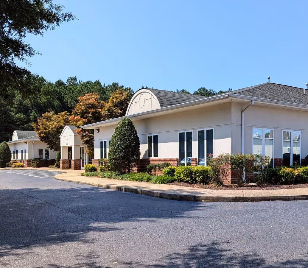 Exterior view of the medical office building entrance and driveway under a clear sky for Cardiology Care in Hopewell