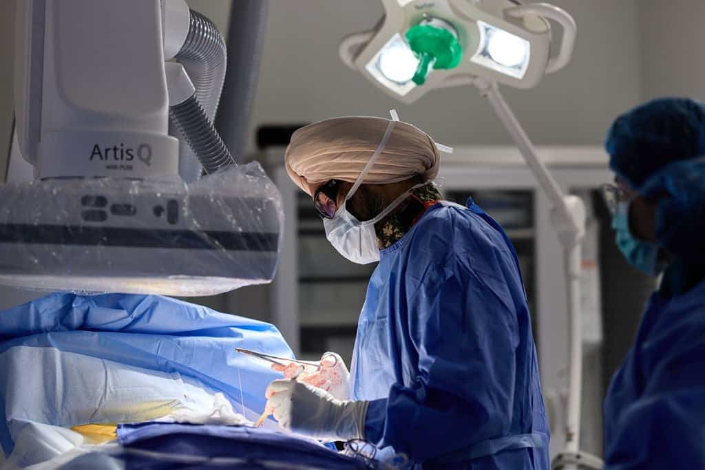 Cardiac electrophysiologist performing a catheter-based cardiac procedure using surgical instruments in an operating suite for Electrophysiology Services