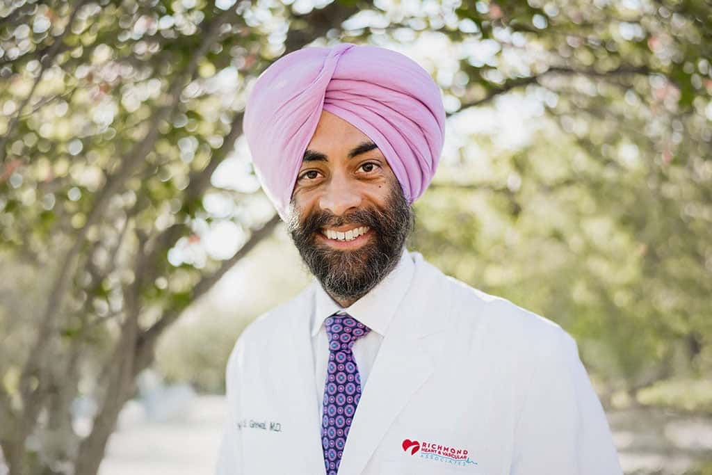 Clinical cardiac electrophysiologist smiling in a white lab coat outdoors for a professional provider portrait of Harpreet Grewal