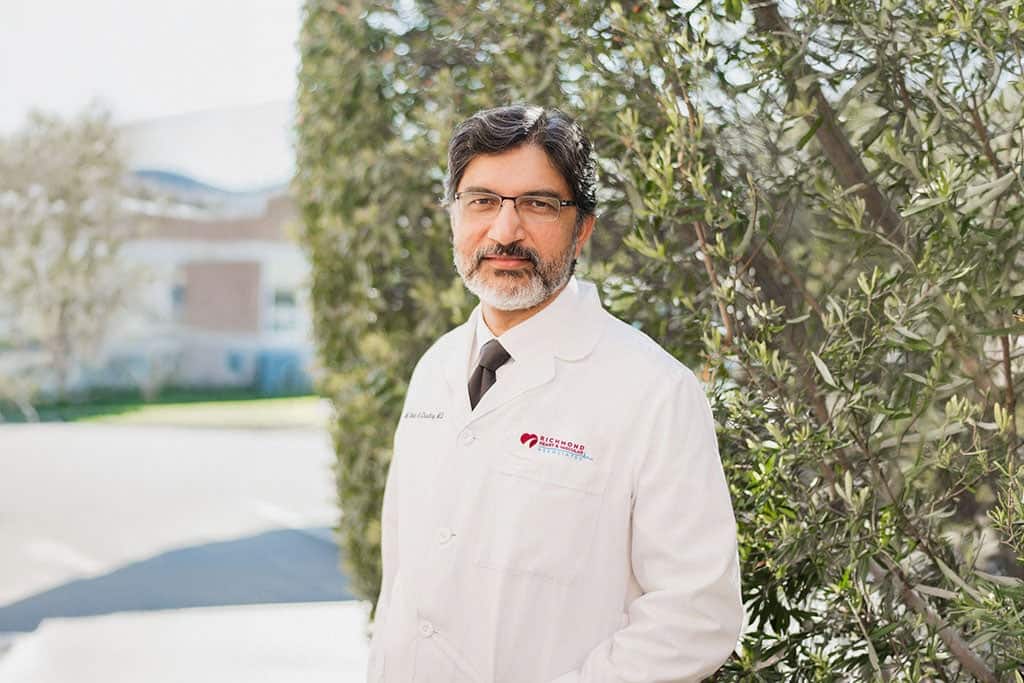Interventional cardiologist smiling in a white lab coat outdoors for a professional provider portrait of Mohammad Sohail Chaudhry MD FACC FSCAI