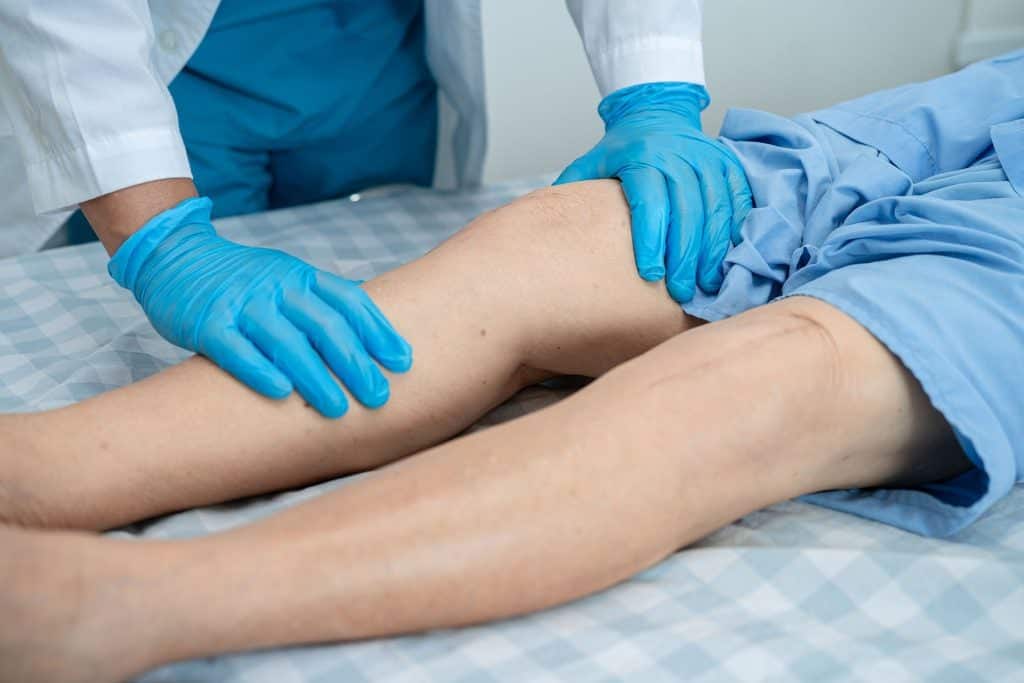 Doctor examining a patient's lower extremity during an evaluation for Peripheral Arterial Disease Treatment