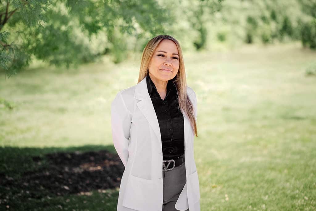 Nurse practitioner posing outdoors in a lab coat for a professional provider portrait of Stephanie Tirone